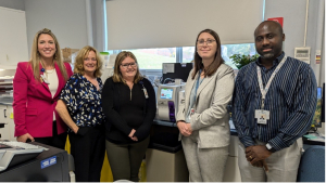 The blood analyser machine sits on the counter between, (l-r), Katie Hogue, VP of Nursing/Clinical Services and Chief Nursing Executive, Joanne Mavis, ED, KDH Foundation, Sabrina, lab technician, Cassandra Mayville-Fortin, RN, KDH Manager of Emergency, Care Quality, &amp; Education and Edwin Nkengla, EORLA Site Operations Manager